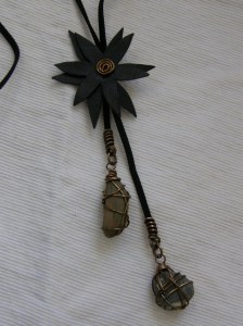 Halsband med blomma av återanvänt läder (från vinterstövel!), prydnads-stenar från trädgården. Blomman går att skjuta upp och ned längs mockabandet.