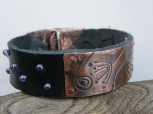 Textured copper with patina, vegetable cured leather (from Slöjd-Detaljer), glass magatama seed beads and waxed linen thread.