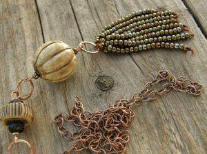 Seed bead and linen yarn tassel, large wooden bead, my own ceramic bead, some Czech glass beads, bronze wire, and copper chain.